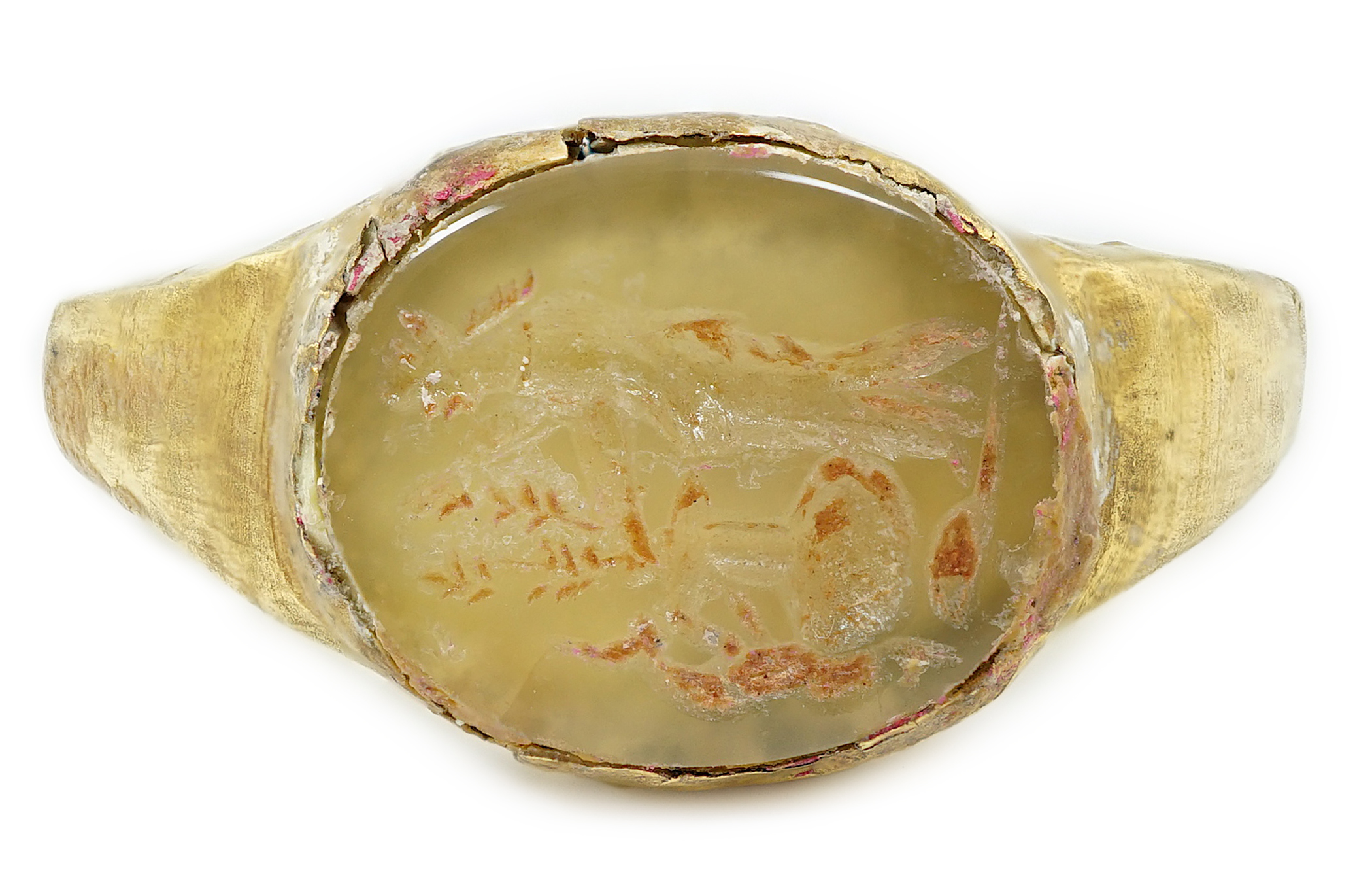 A Roman gold and hardstone intaglio military finger ring, carved with Saturn beside a pedestal